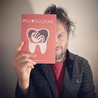 a man holding up a magazine with a tooth on it