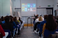 a woman giving a presentation to a group of people