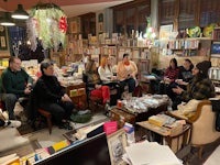 a group of people sitting in a room full of books